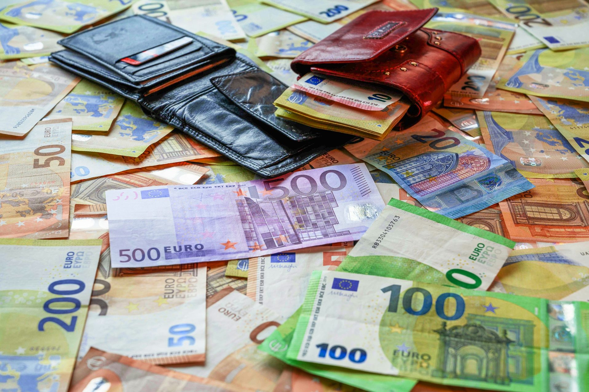 Geldscheine und Geldbörsen auf einem Haufen Euroscheine nach Kredit trotz negativer Schufa